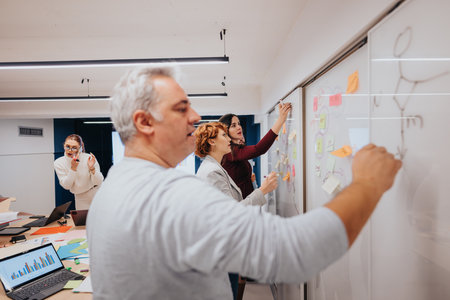 Business coworkers discuss and analyze statistics, brainstorm ideas, and plan for successful growth....