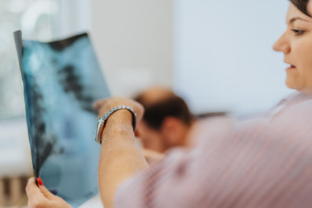 Medical office visit: Expert doctor examines elderly patients lungs, reviews x-ray film, provides...