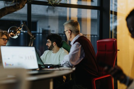 Businesspeople discuss business growth and profit statistics, strategize for market expansion and sales success in late evening meeting at the office.の写真素材