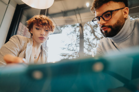 Colleagues discussing business model for market expansion. Analyzing statistics and financial reports for profit growth. Positive atmosphere and teamwork.の写真素材