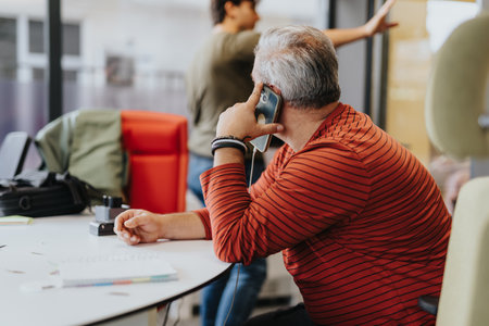 Urban entrepreneur seals deals over a call, crafting a new project amidst the citys hustle.の写真素材