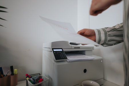 Colleagues print docs, talking business and planning for the market.の写真素材