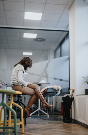 Female employee taking a rest from work at modern office kitchen.の写真素材