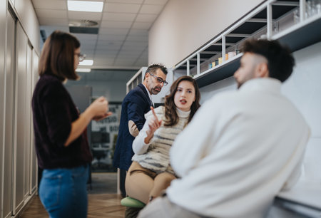 Creative team discussing ideas or opportunities and enjoying a pleasant atmosphere in a modern kitchen.の写真素材