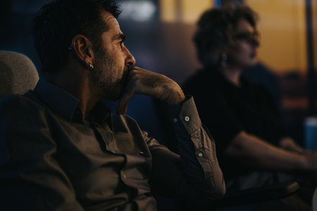 Corporate business people collaborating and strategizing for success in an indoor evening meeting at the office.の写真素材