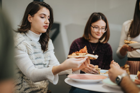 Successful business people taking a refreshing break and enjoying pizza together in the workplace.の写真素材