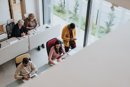 Group of people working together in a modern office. They collaborate, discuss project solutions and show great teamwork in a multicultural workplace.の写真素材