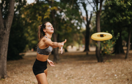Active women playing frisbee outdoors, enjoying a sunny day in the park. Fit, sporty, and having fun...
