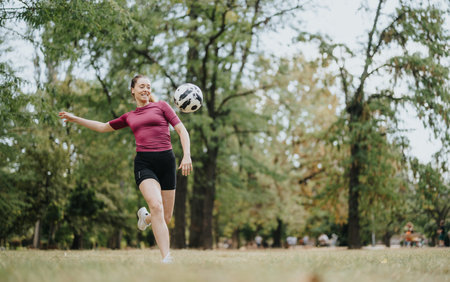 Female, football player kicking a football in the air. Copy space.の写真素材