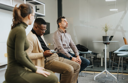 A diverse team of business professionals collaborating and discussing ideas in the office for...