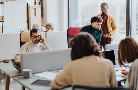 Business team working together in modern office. Multiracial and multigenerational teamwork in a corporate environment.の写真素材