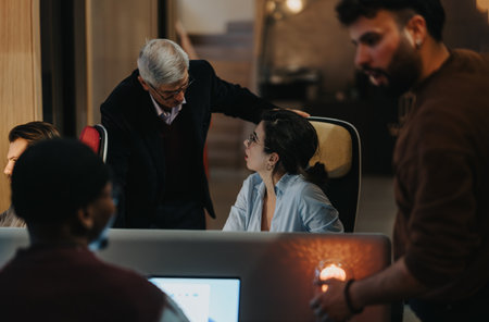 Senior manager guiding young professionals in corporate office setting