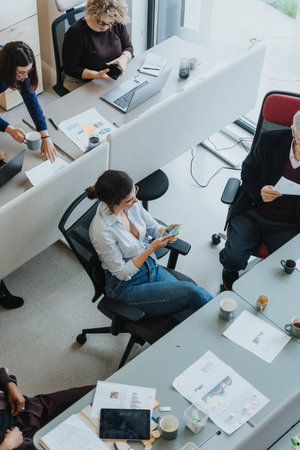 High-angle shot of a diverse group of employees engaged in a collaborative work setting in a contemporary office.の写真素材