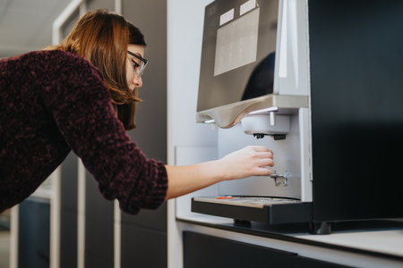 A photo of gorgeous female person taking a coffee from the coffee maker.