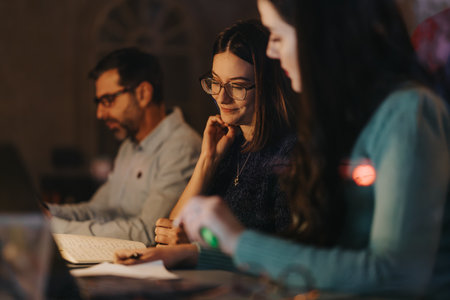 Focused company employees engaged in a productive business meeting at evening time.