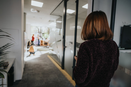 Gorgeous female employee holding a cup of tea while walking in a modern hall.