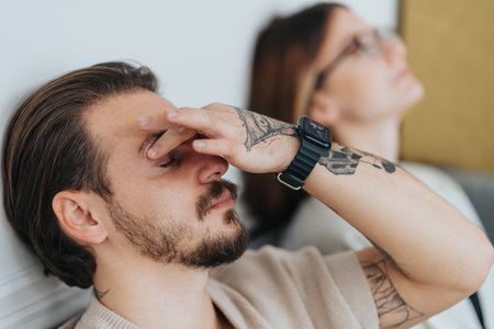 Male person massaging his eyes while taking a break from work.