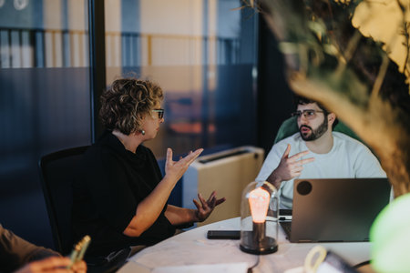 Employees discuss business growth, market expansion, profitability, and success in an evening office...