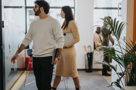Cheerful businesspeople discussing and sharing ideas in a modern co-working spaceの写真素材
