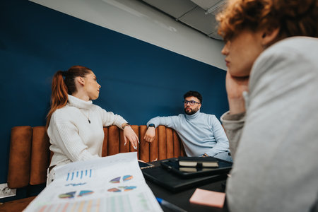 Business professionals collaborating in a creative office, analyzing stats and brainstorming ideas for business expansion.の写真素材