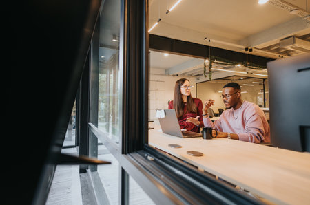 Positive atmosphere: Creative office of multiracial businesspeople collaborating on project development and data analyticsの写真素材