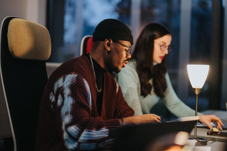 Focused multiracial business colleagues discuss strategy in a well-lit, contemporary office environment, showcasing teamwork and collaboration.の写真素材