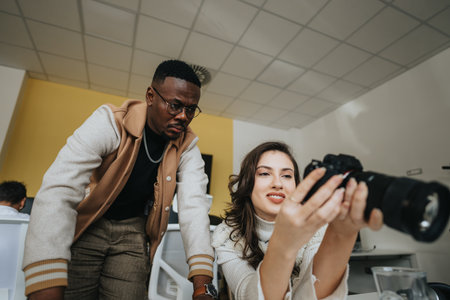 Lovely woman showing a picture that she has taken to her male colleague at work.の写真素材