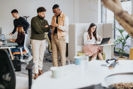 Blurred photo of business colleagues collaborating in a creative office, discussing reports and strategizing for success.の写真素材
