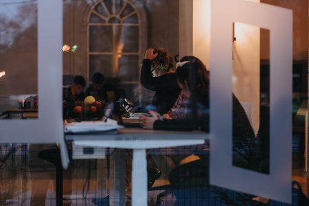 Group of diverse colleagues engaged in work after hours at office.の写真素材