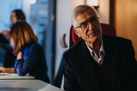 Senior executive reflecting on strategy during office meeting with team.の写真素材