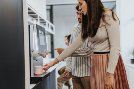 Business woman making her first morning coffee at work.の写真素材