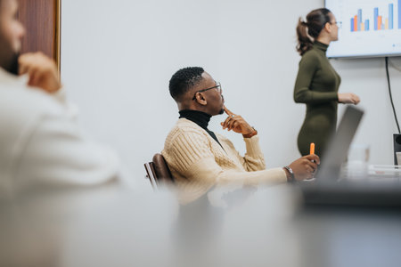 Diverse business team analyzing statistics, discussing ideas, and working together in a creative workplace environment.の写真素材