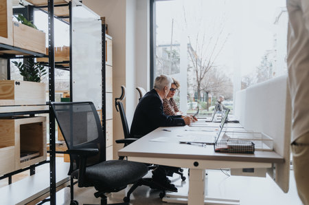 Senior team of coworkers working together on a successful business project in an innovative office