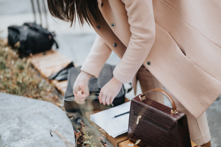 Professional woman signing contract outdoors with elegant attire and accessoriesの写真素材