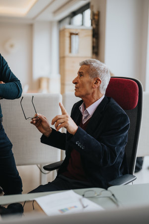 Senior business executive engaging in discussion at office meetingの写真素材