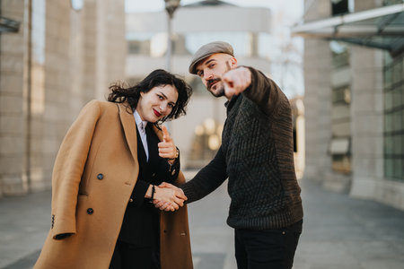 Stylish young couple holding hands and smiling in urban setting.の写真素材