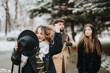 A cheerful moment captured as young businesspeople enjoy a snowy day outdoors, showcasing camaraderie and a break from work life.の写真素材