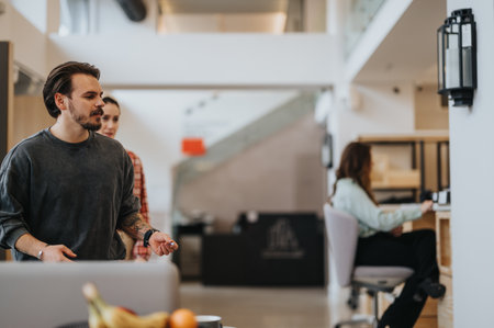 Young professionals in a casual meeting in a contemporary office kitchen space. Concept of teamwork and collaboration in a relaxed setting.の写真素材