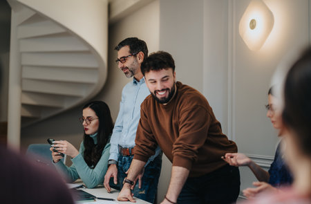 Dynamic image of a collaborative team engaging in a discussion at a modern office environment, with a focus on teamwork and communication.の写真素材