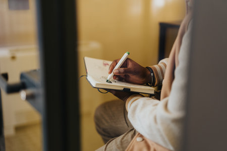 The handsome man sketches ideas in his notebook using a vibrant green marker. Close up.の写真素材