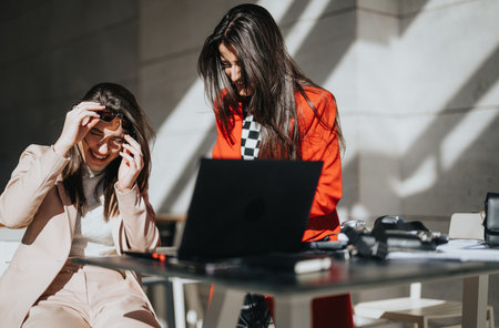 Overjoyed, businesswomen laughing at a casual business meeting outdoors.の写真素材