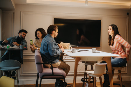 Young adults engaging in casual conversation in a modern cafe setting