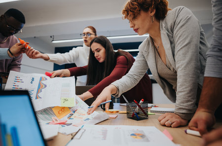 Company employees collaborate in a business lecture, discussing stats and charts for successful outcomes.の写真素材