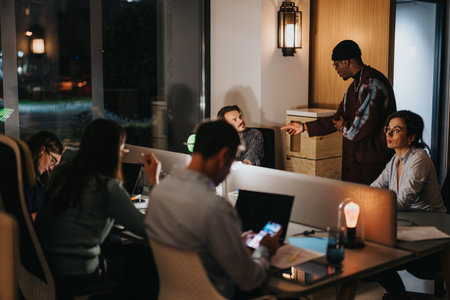 Multicultural, cross generational business people engaged in nighttime office meeting.