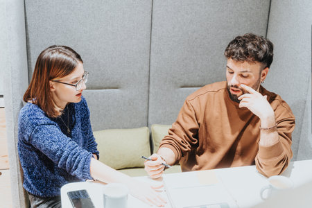 Focused colleagues discussing project strategy at modern office.