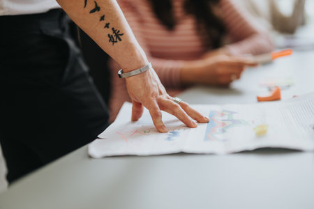 Close-up of business employees engaging in a collaborative business meeting, with focus on hands and documents.の写真素材