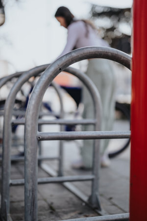 Urban bicycle parking rack with blurred woman in background.の写真素材