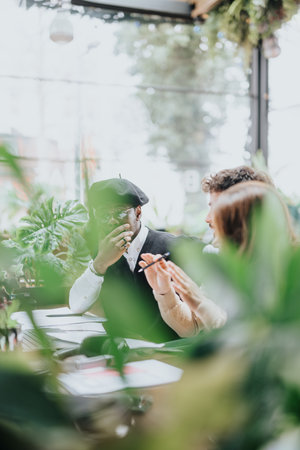 Diverse business colleagues engaging in strategy discussion at a cafe.の写真素材