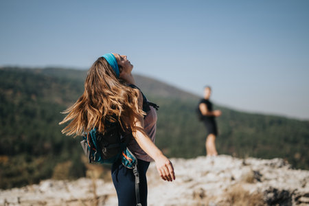 Happy adults exploring a scenic mountain trail on a sunny day, enjoying natures beauty and engaging in outdoor activities.の写真素材