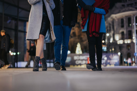 Close-up of friends walking together in urban evening settingの写真素材